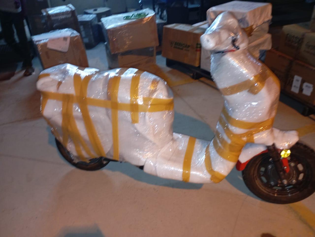 Rear view of a scooter wrapped in protective packaging material for transit safety